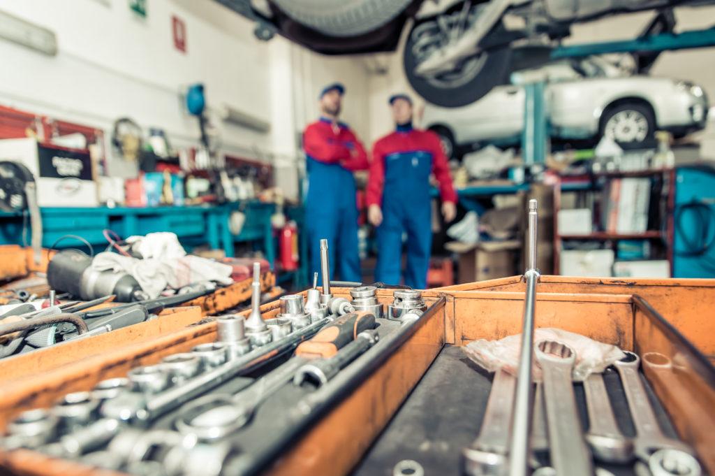 Two mechanics working on a car